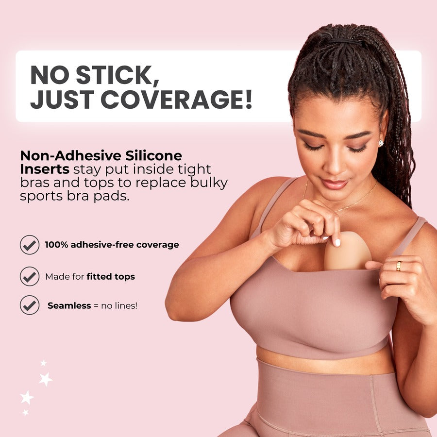 A woman wearing non-adhesive silicone insert by pulling the bra cup away from her skin. The image features marketing text on a soft pink background explaining the product's adhesive-free coverage.
