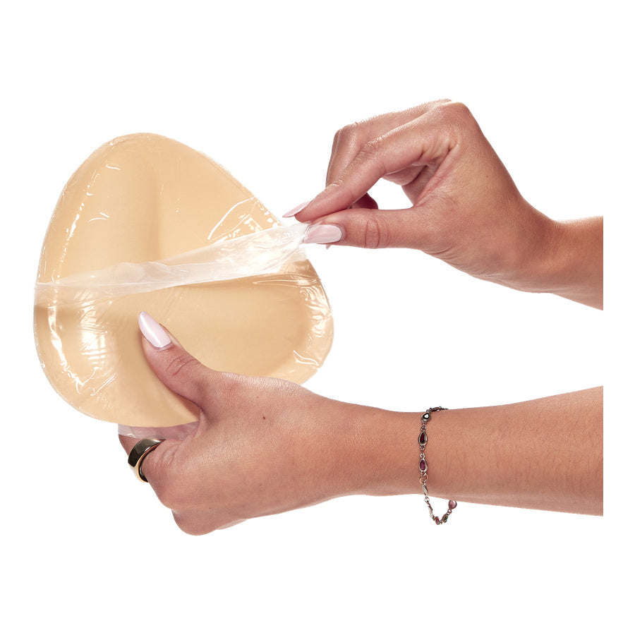 Breast cups being peeled from protective plastic