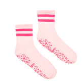 Pair of pink grip socks with white soles and red stripes on a white background