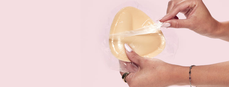 A person holding a Double-Sided Adhesive Push-Up Bra and removing the wrapper. 