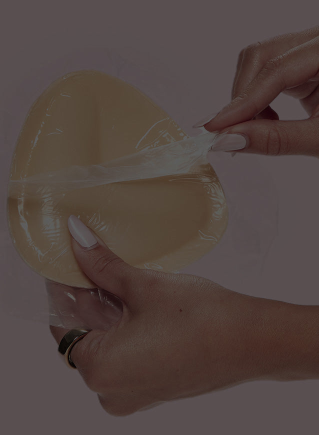 A person holding a Double-Sided Adhesive Push-Up Bra and removing the wrapper. 