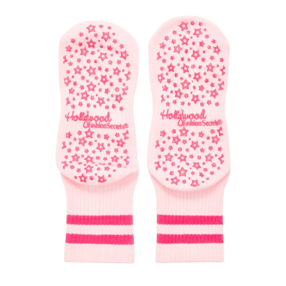 Pair of pink grip socks with star pattern and 'Hollywood' branding on a white background