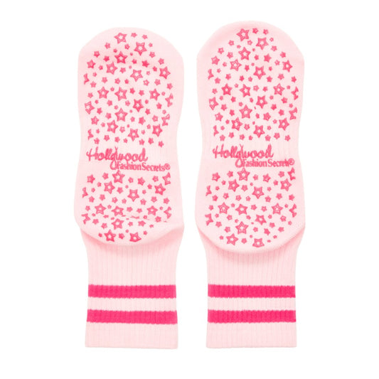 Pair of pink grip socks with star pattern and 'Hollywood' branding on a white background