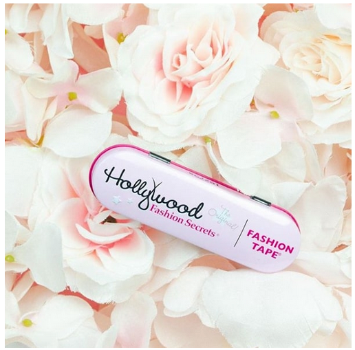 Fashion Tape Product Shot on Flowers – Hollywood Fashion Secrets Fashion Tape tin displayed on a bed of pink and white flowers for a stylish look.