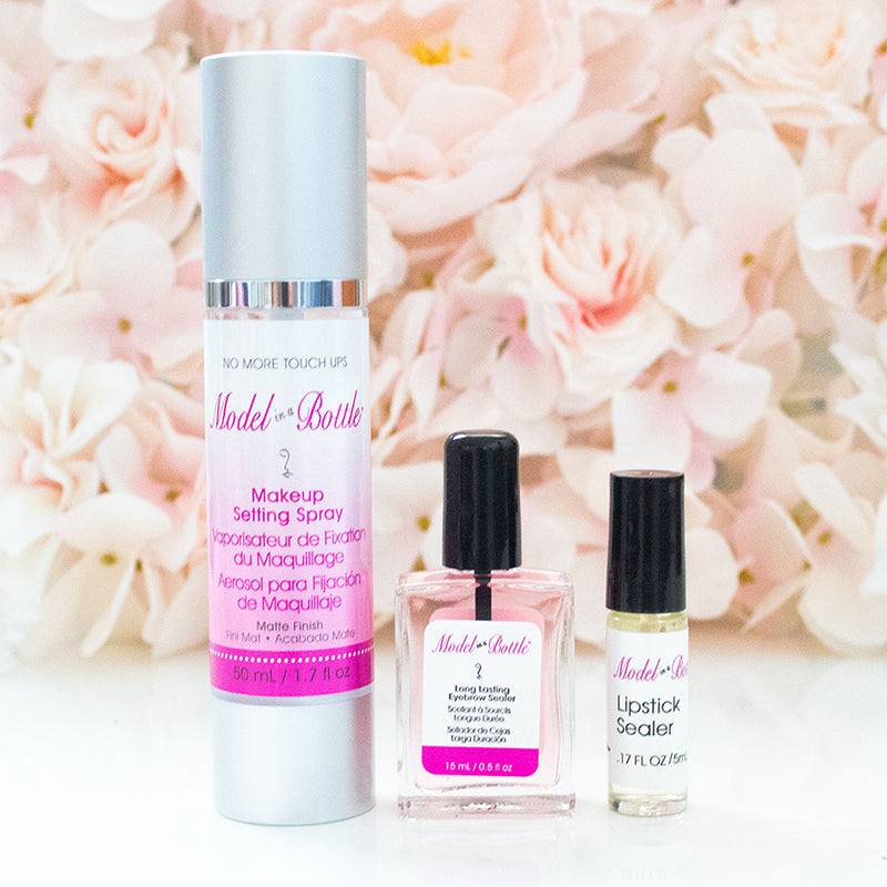 Makeup setting spray and lip products with a floral background