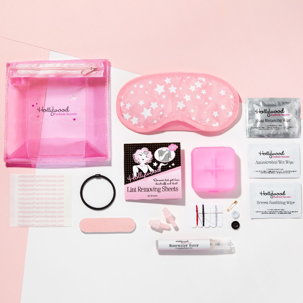 Top view of Hollywood ashion Secrets 13 piece travel essentials lay on a white and pink floor