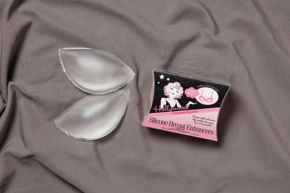 Breast inserts inside and outside its sealed packaging lay on a gray fabric