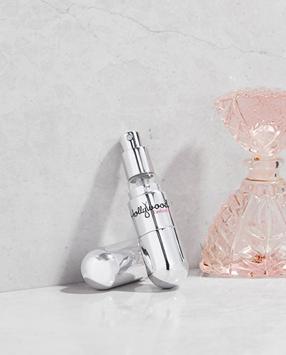 Hollywood Fashion Secrets Perfume Atomizer displayed stylishly next to a perfume bottle on a marble surface.